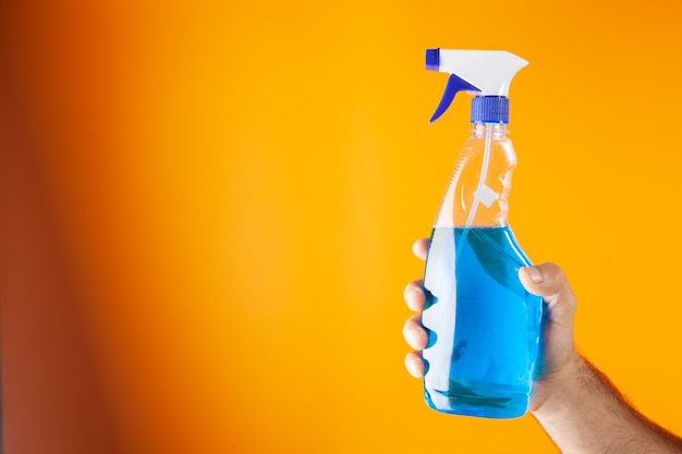 Man holding detergent on orange background