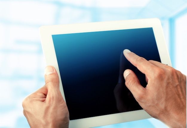 Man holding   digital tablet on background