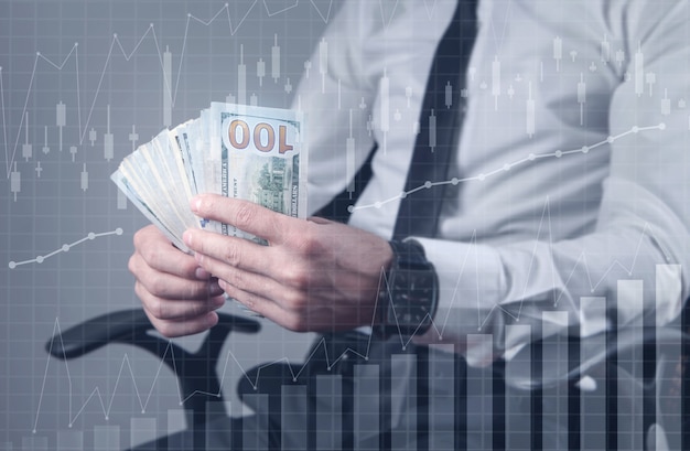 Man holding dollar banknotes with growth graph.