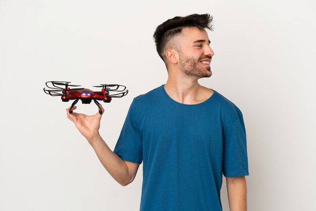 Man holding a drone isolated on white background looking side