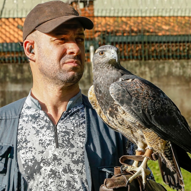 Foto uomo che tiene un'aquila pettonero