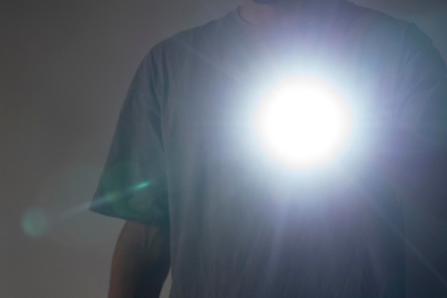 A man holding an electric light torch in the dark space