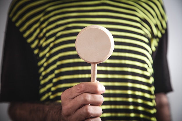 Man holding empty wooden round.