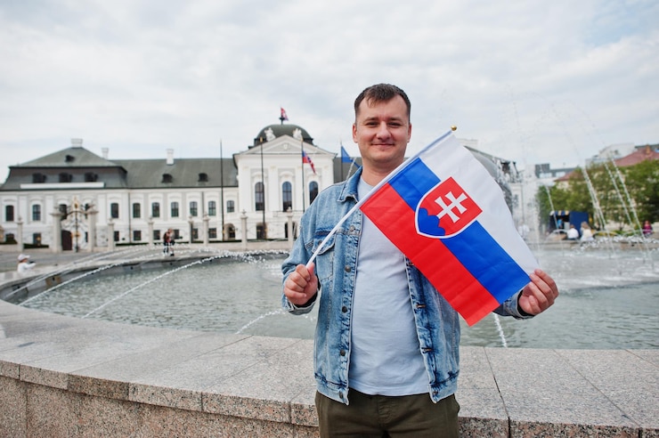 Photo man holding flag at grassalkovich palace bratislava europe residence of the president of slovakia in bratislava
