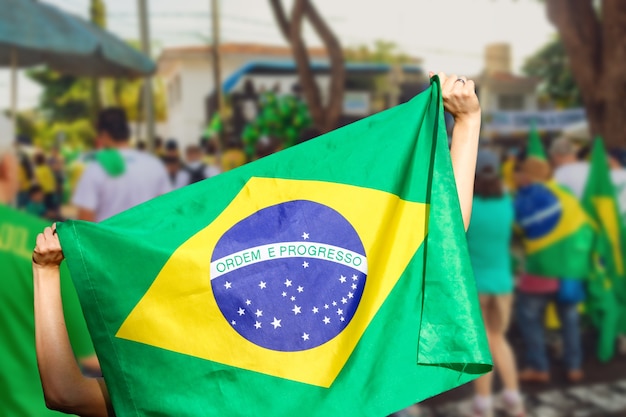 ブラジルの街頭デモで旗を掲げる男。