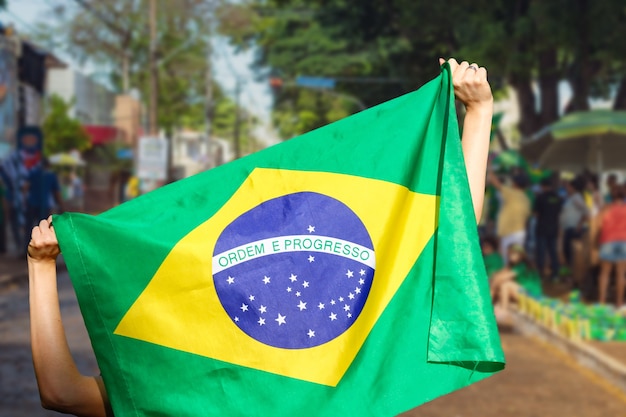 ブラジルの街頭デモで旗を掲げる男。