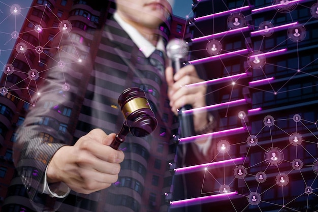 A man holding a gavel in front of a digital display.