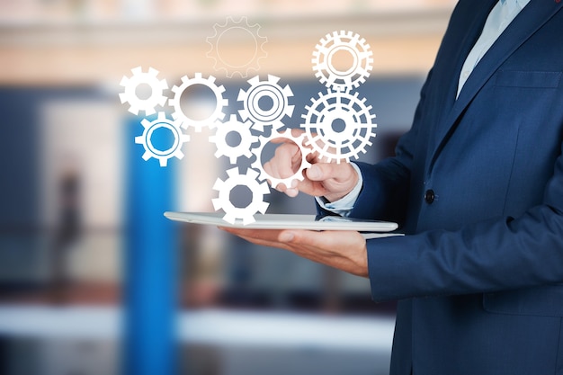 Photo man holding gears in tablet screen