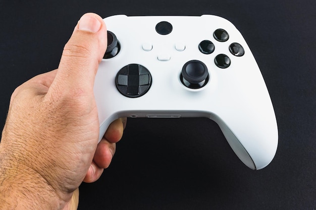 Man holding a Next generation white game controller isolated on black background.