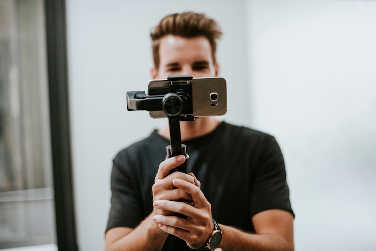 Photo man holding a gimbal with a phone