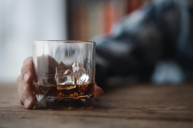 ブランデーのグラスを持っている男は、アルコールを飲んでいるバーでブランデーを飲んでいる運転能力を損ない、健康を害する可能性があります アルコールを飲むという概念