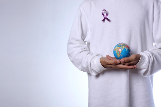 Man holding globe and wearing cancer ribbon