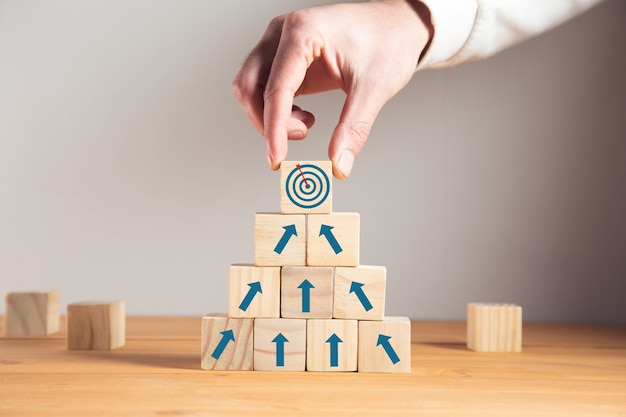 Man holding goals with arrows on cubes