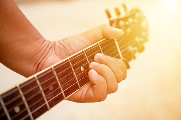 Man holding guitar with sun light