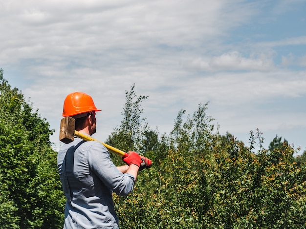 Man holding a hammer in the park