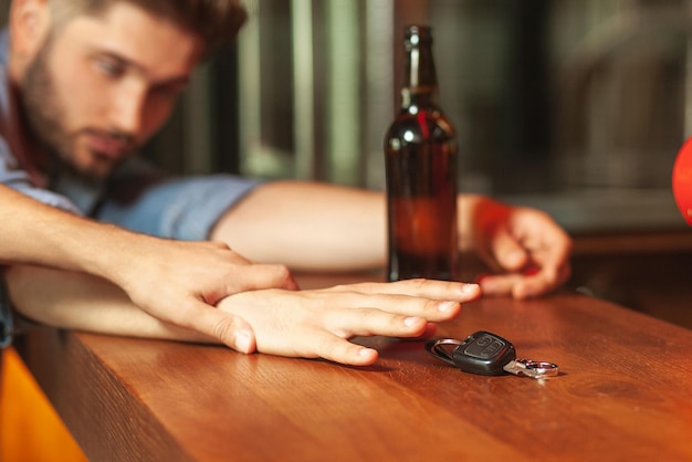 Мужчина держит за руку своего пьяного друга с ключами от машины