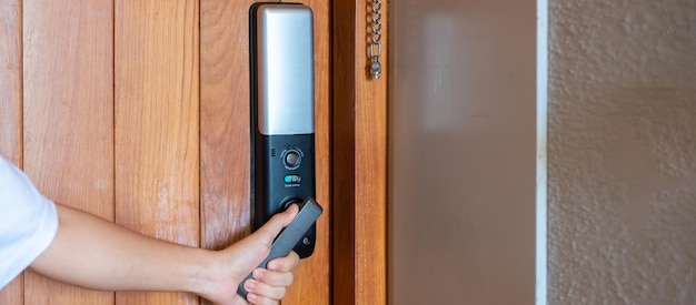Photo man holding handle of smart digital door lock while open or close the door technology electrical and lifestyle concepts