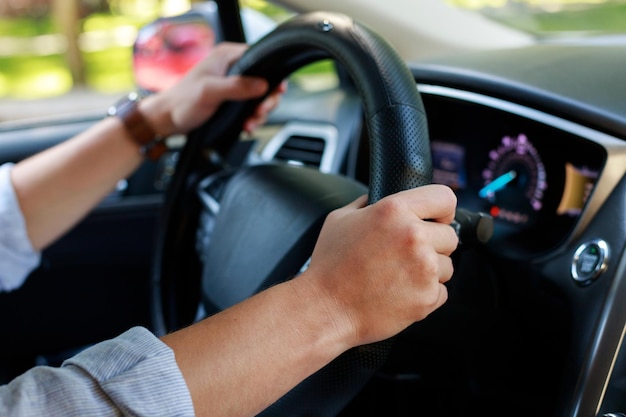 Man holding hands on steering wheel close up