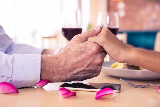 Man holding hands of woman