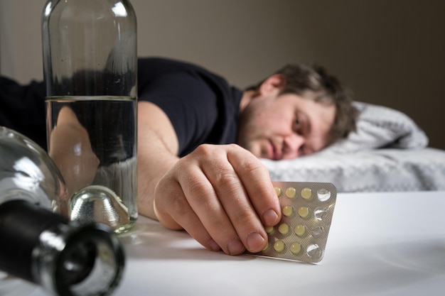 A man holding hangover pills in his hand