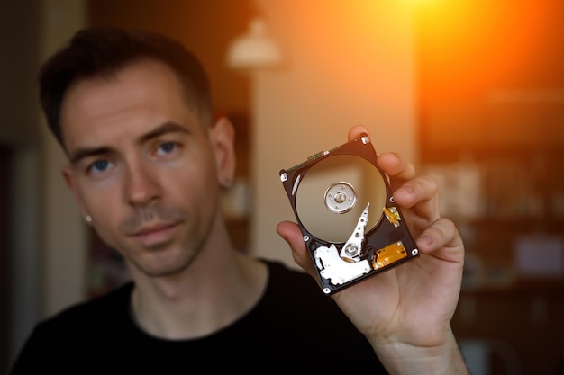 Un uomo che tiene in mano un disco hdd