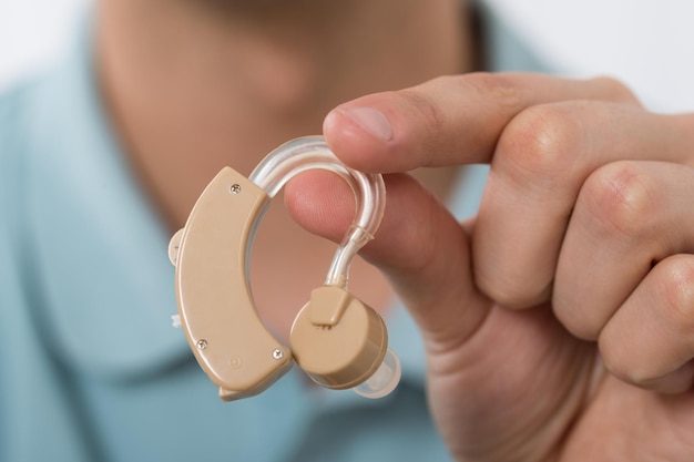 Photo man holding hearing aid