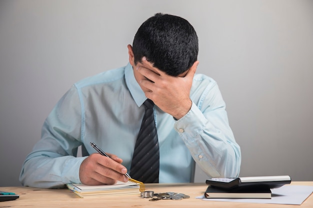 A man holding his head in the hands of a desktop