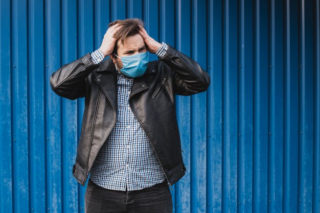 Man holding his head with hands wearing mask. coronavirus quarantine. place for text, copyspace