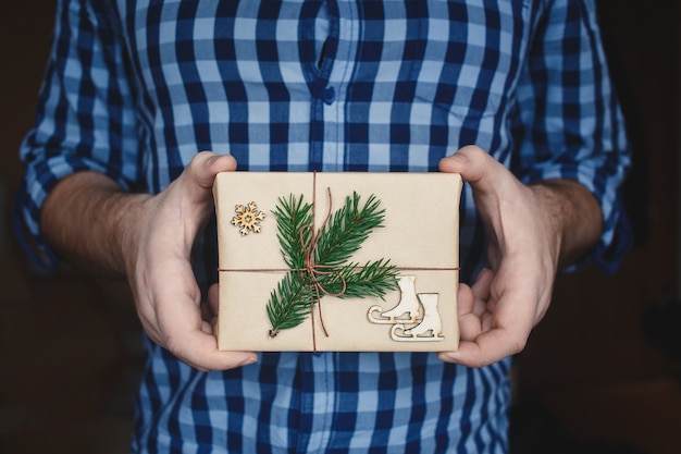 Man holding homemade wrapped Christmas Present