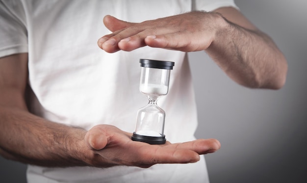 Photo man holding hourglass deadline concept