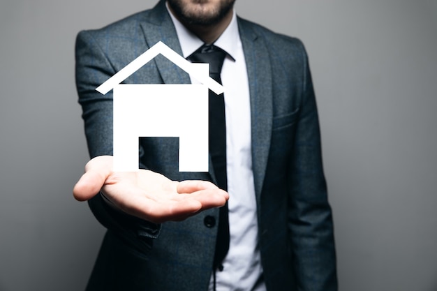 A man holding a house icon in his hand