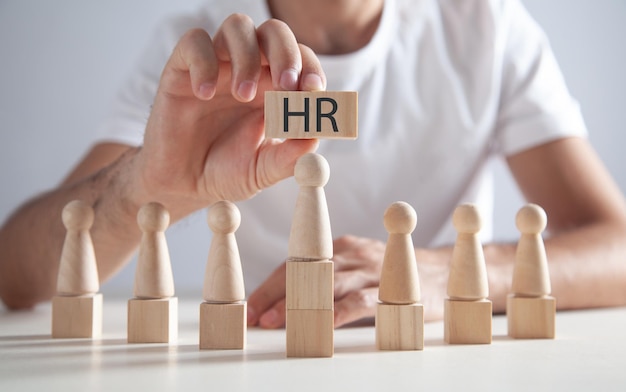 Man holding HR word on wooden cubes Human Resources