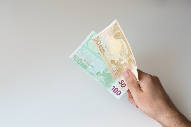 Man holding a hundred and fifty Euro banknote in his hand