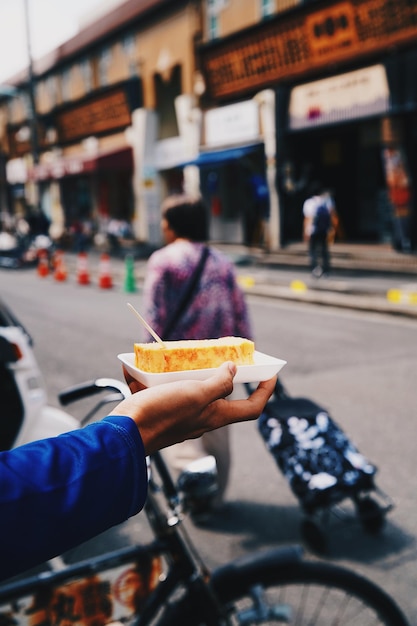 Photo man holding ice cream on street in city