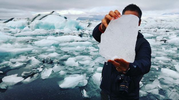 Photo man holding iceberg at beach