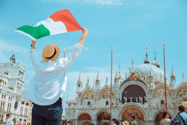 Man holding italian fag in rise up hands venice central square san marco