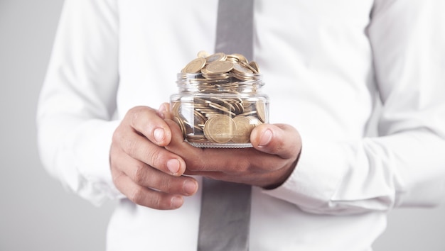 Man holding jar of coins.