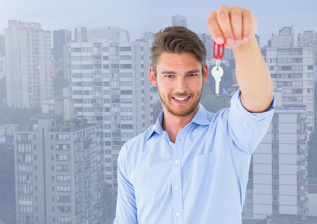 Photo man  holding key in front of high rise apartments