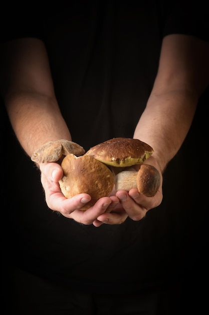 Man holding king bolete in hand Rustic style