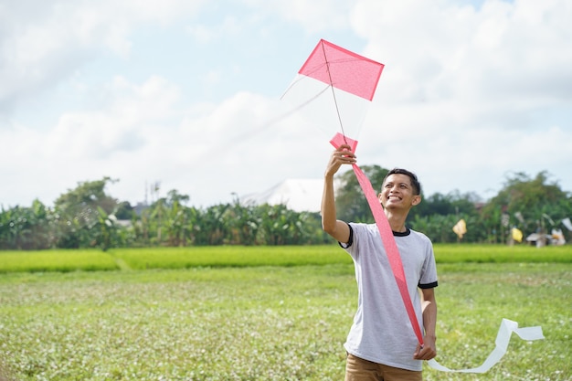 Photo a man holding a kite to be flown