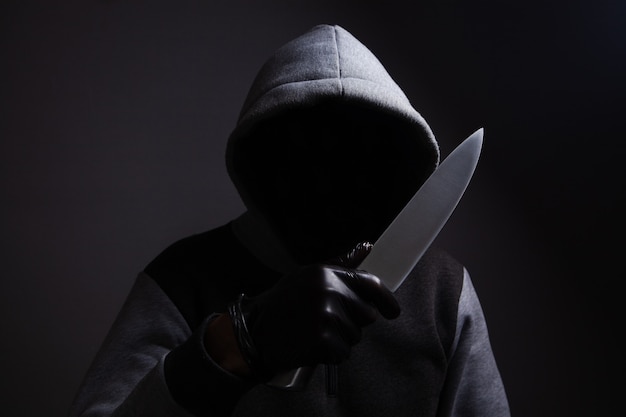 A man holding a large knife threatens