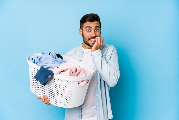 Man holding laundry basket biting fingernails