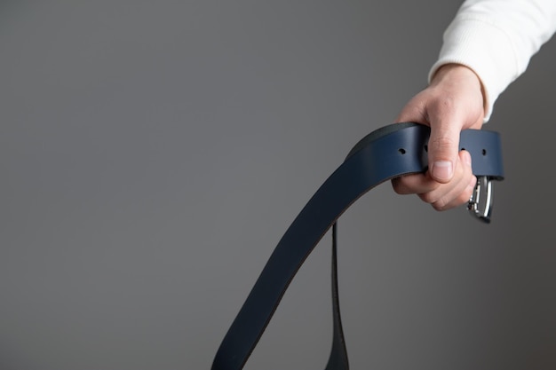 man holding leather belt for punishment