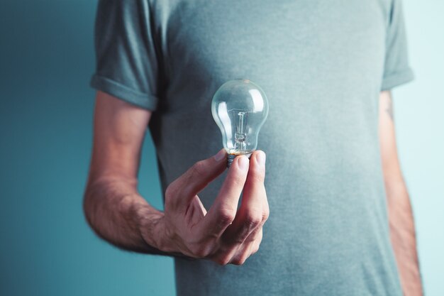 Un uomo con in mano una lampadina