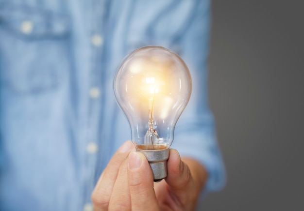 電球を持っている人、革新的な技術と創造性を備えた新しいアイデアのアイデア。