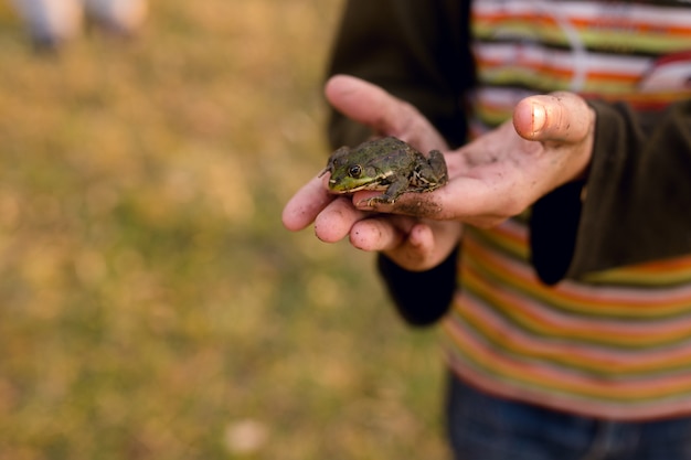 Man holding a little frog in his hands