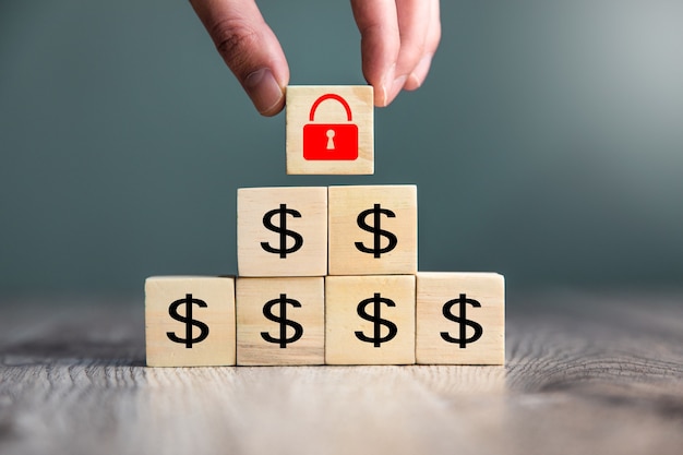 man holding lock with dollar on cube