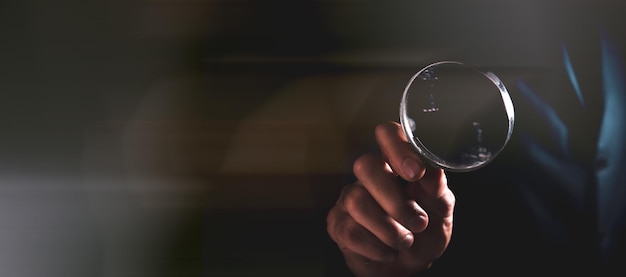 Man holding a magnifying glass in his hands search for information