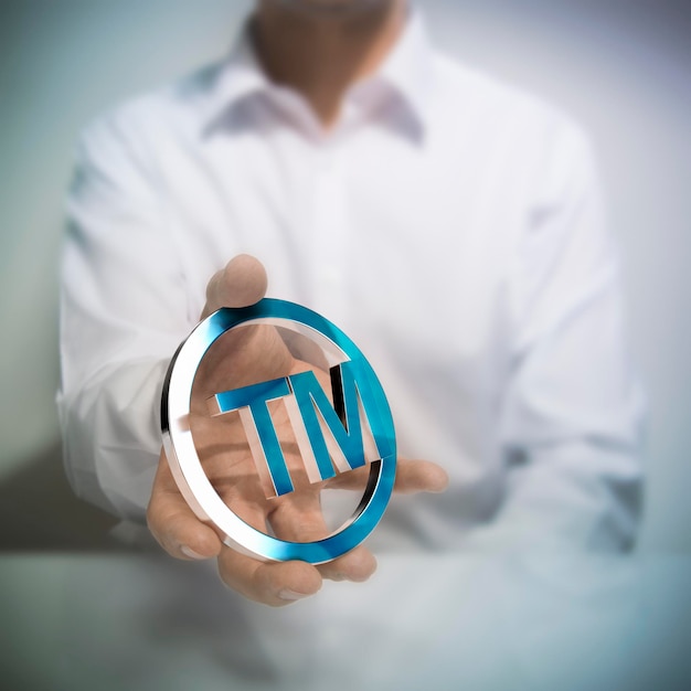 Photo man holding metallic trademark symbol. concept image for illustration of intellectual property or protection of products or services.