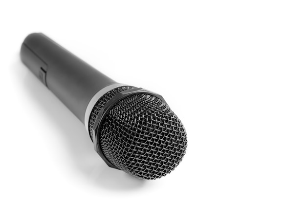 A man holding a microphone on a white surface